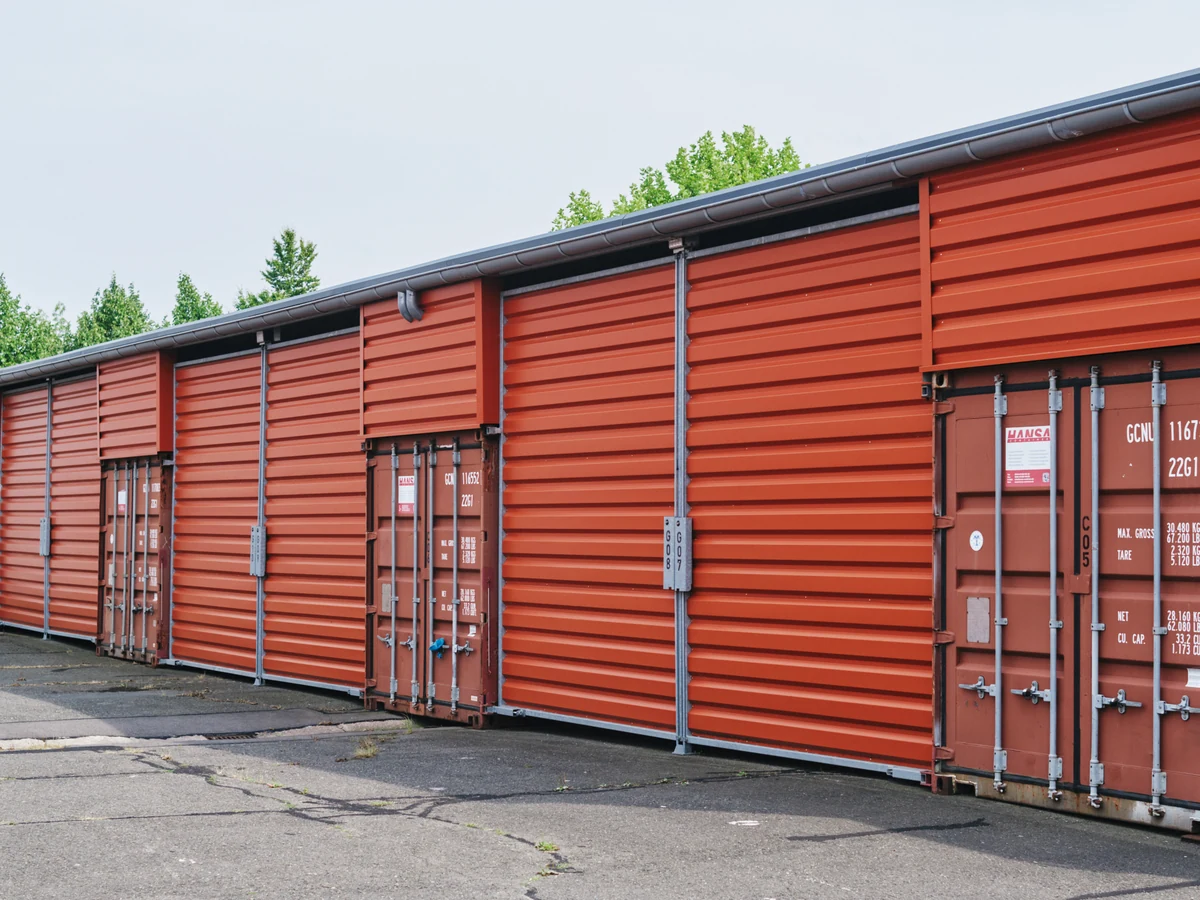 Reihe orangefarbener Lagercontainer, ebenerdig auf dem Hof der Anlage